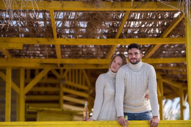 Sonbahar boyunca boş sahil barında birlikte bira içen çift.