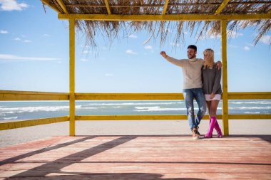 Mutlu çift, sonbahar günü kumsalda birlikte vakit geçiriyorlar.