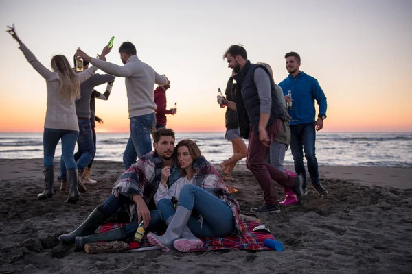 Pareja Joven Disfrutando Con Amigos Alrededor Campfire Playa Atardecer Bebiendo —  Fotos de Stock