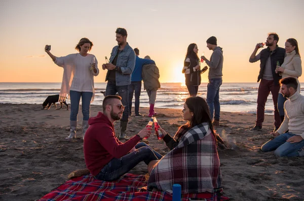 Pareja Joven Disfrutando Con Amigos Alrededor Campfire Playa Atardecer Bebiendo —  Fotos de Stock