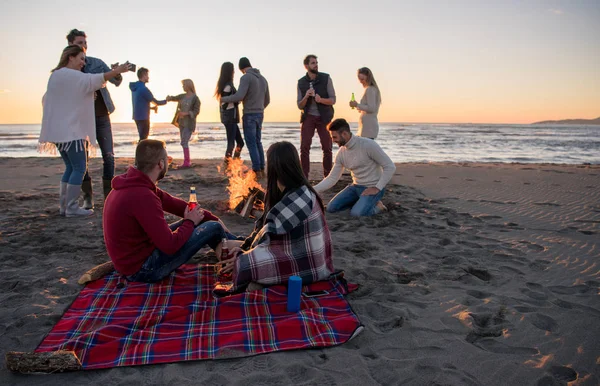 Pareja Joven Disfrutando Con Amigos Alrededor Campfire Playa Atardecer Bebiendo — Foto de Stock