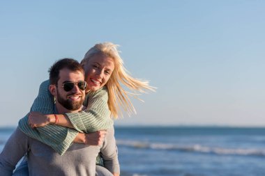 Erkekler, sonbahar zamanı, Sunset By The Sea 'de sevgilisine sırt sırta biniyor.