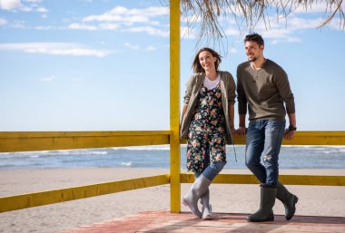 Mutlu çift, sonbahar günü kumsalda birlikte vakit geçiriyorlar.