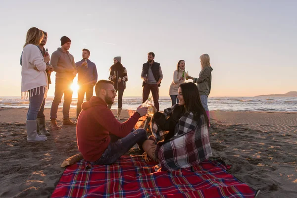 Pareja Joven Disfrutando Con Amigos Alrededor Campfire Playa Atardecer Bebiendo — Foto de Stock