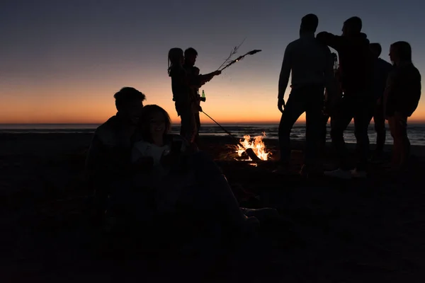 Para Korzystająca Telefonu Komórkowego Podczas Jesiennej Imprezy Plaży Przyjaciółmi Pijącymi — Zdjęcie stockowe