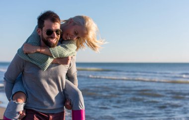 Erkekler, sonbahar zamanı, Sunset By The Sea 'de sevgilisine sırt sırta biniyor.