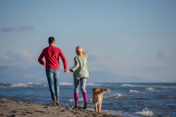 Pareja Corriendo Playa Sosteniendo Sus Manos Con Perro Día Autmun — Foto de Stock