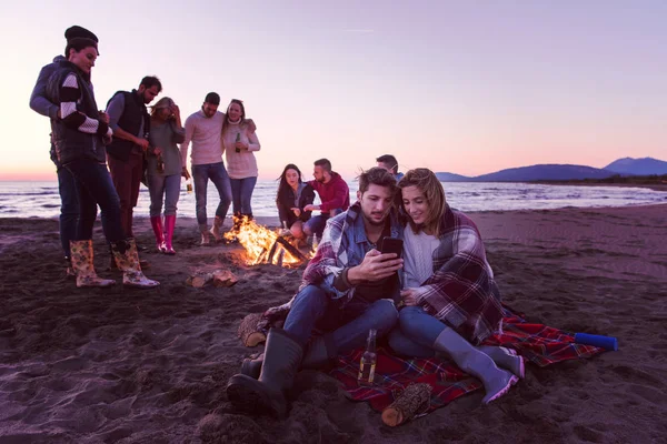 Par Som Använder Mobiltelefon Höstens Strandfest Med Vänner Som Dricker — Stockfoto