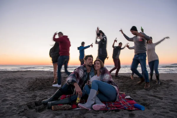 Молода Пара Насолоджується Друзями Пляжі Кемпфайр Під Час Заходу Пиво — стокове фото