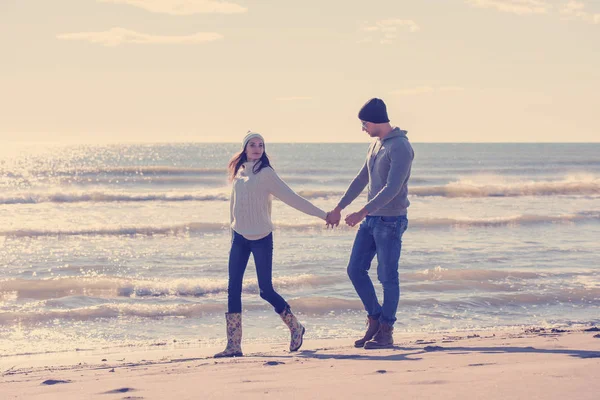 秋の晴れた日にビーチで遊んだり抱き合ったりしている若いカップル — ストック写真