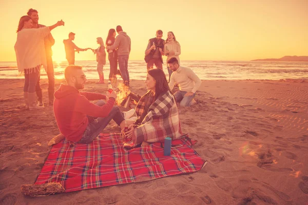 Junges Paar Genießt Mit Freunden Lagerfeuer Strand Bei Sonnenuntergang Bier — Stockfoto