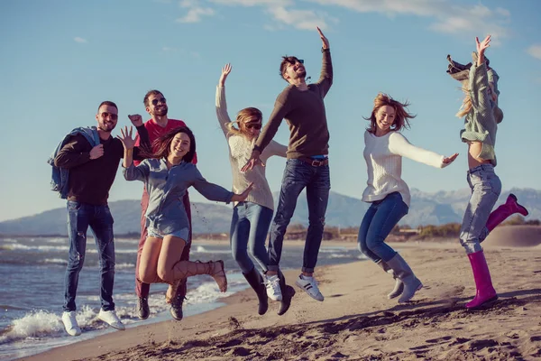 Bir Grup Heyecanlı Genç Arkadaş Güneşli Sonbahar Kumsalında Birlikte Zıplıyorlar — Stok fotoğraf
