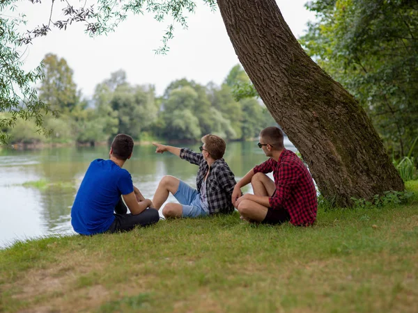 Group Young Men Enjoying Nature Sitting Bank River — Stock Photo, Image