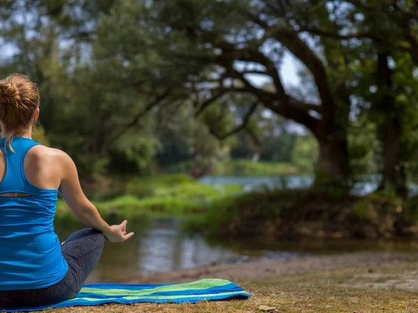 リラックスした瞑想とヨガを行使する川の銀行の美しい自然の中 健康的な女性 — ストック写真