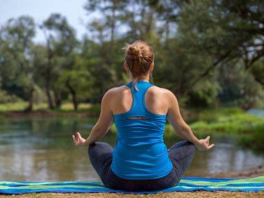 sağlıklı kadın meditasyon ve yoga yaparken Nehri kıyısında güzel doğada egzersiz yaparken rahatlatıcı