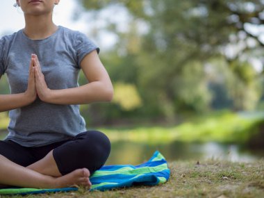 sağlıklı kadın meditasyon ve yoga yaparken Nehri kıyısında güzel doğada egzersiz yaparken rahatlatıcı