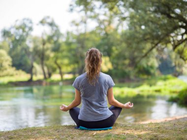 sağlıklı kadın meditasyon ve yoga yaparken Nehri kıyısında güzel doğada egzersiz yaparken rahatlatıcı