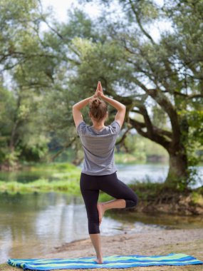 sağlıklı kadın meditasyon ve yoga yaparken Nehri kıyısında güzel doğada egzersiz yaparken rahatlatıcı