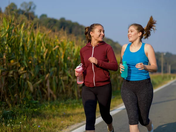 Dwie Młode Kobiety Korzystających Zdrowego Trybu Życia Podczas Joggingu Wzdłuż — Zdjęcie stockowe