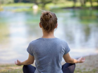 sağlıklı kadın meditasyon ve yoga yaparken Nehri kıyısında güzel doğada egzersiz yaparken rahatlatıcı