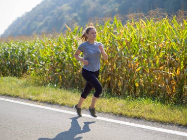 Genç kadın bir ülke road, egzersiz ve fitness kavramı koşu sırasında sağlıklı bir yaşam tarzı zevk