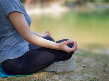 sağlıklı kadın meditasyon ve yoga yaparken Nehri kıyısında güzel doğada egzersiz yaparken rahatlatıcı