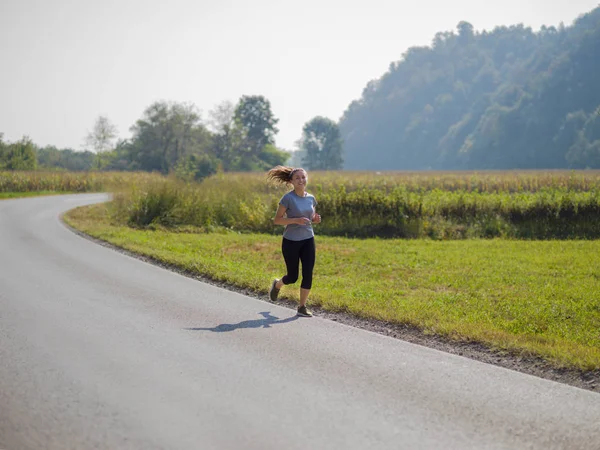 Молодая Женщина Наслаждающаяся Здоровым Образом Жизни Время Пробежки Сельской Дороге — стоковое фото