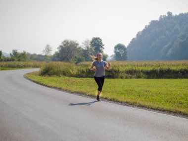 Genç kadın bir ülke road, egzersiz ve fitness kavramı koşu sırasında sağlıklı bir yaşam tarzı zevk