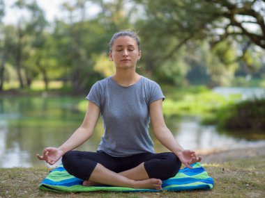sağlıklı kadın meditasyon ve yoga yaparken Nehri kıyısında güzel doğada egzersiz yaparken rahatlatıcı