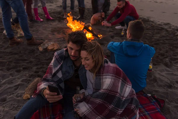 Pareja Usando Teléfono Celular Durante Fiesta Otoño Playa Con Amigos —  Fotos de Stock