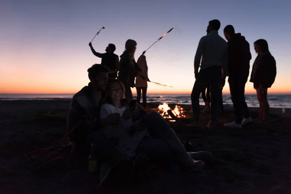 Paar Met Behulp Van Mobiele Telefoon Tijdens Herfst Strandfeest Met — Stockfoto