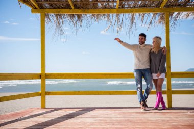 Mutlu çift, sonbahar günü kumsalda birlikte vakit geçiriyorlar.