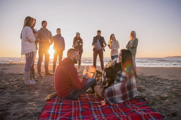 Pareja Joven Disfrutando Con Amigos Alrededor Campfire Playa Atardecer Bebiendo —  Fotos de Stock