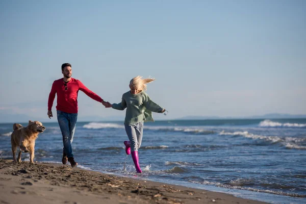 Para Biegająca Plaży Trzymająca Się Ręce Psem Dniu Autmun — Zdjęcie stockowe