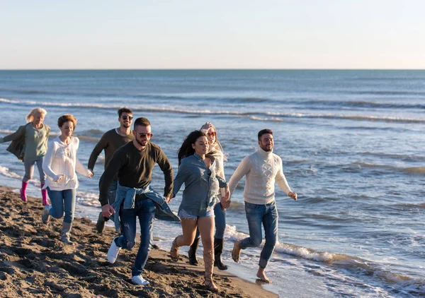Bir Grup Genç Arkadaş Güz Günü Boyunca Kumsalda Birlikte Koşuyorlar — Stok fotoğraf