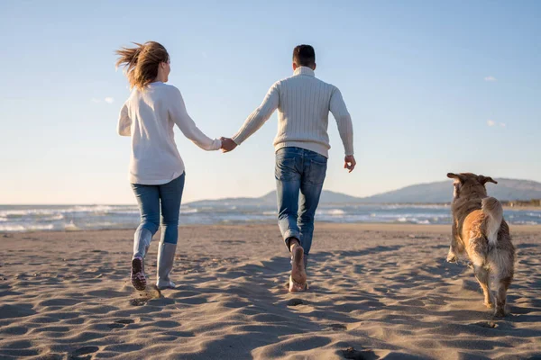 Pareja Corriendo Playa Sosteniendo Sus Manos Con Perro Día Autmun —  Fotos de Stock