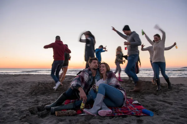 Fiatal Pár Élvezi Barátaival Körül Tábortűz Strandon Naplementekor Sört Iszik — Stock Fotó