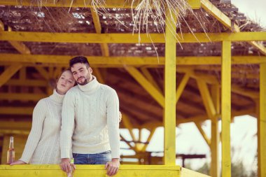 Genç çift bira birlikte boş plaj barda sonbahar süre içinde içme.