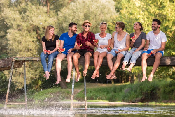 Skupina Mladých Přátel Sedí Dřevěný Most Přes Řeku Vody — Stock fotografie