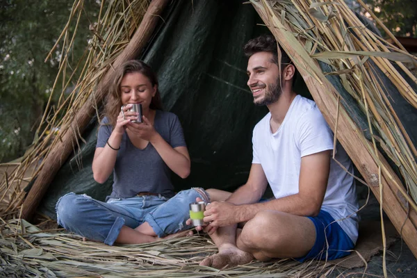 情侣在爱旅行和花时间一起在稻草帐篷 而喝热茶的河流 — 图库照片