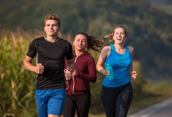 Grupa Młodych Ludzi Jogging Podismo Drogowego Kraju Działa Otwartej Drodze — Zdjęcie stockowe