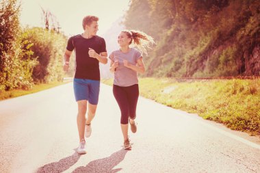 Genç çift ülke yolda koşu sırasında sağlıklı yaşam tarzı zevk