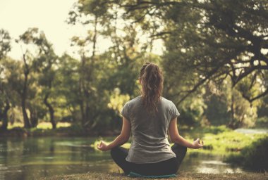 sağlıklı kadın meditasyon ve yoga yaparken Nehri kıyısında güzel doğada egzersiz yaparken rahatlatıcı