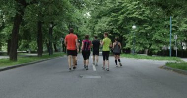 Bir grup koşucu şehir parkında birlikte koşarken arkadan görülmüş.