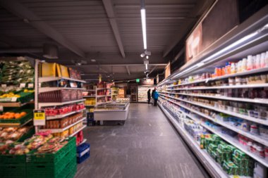 Modern süpermarketten alışveriş yapan ve fiyatları ve malzemeleri kontrol eden bir grup insan