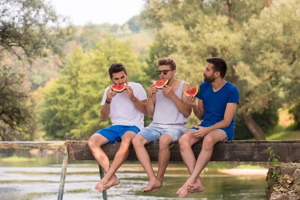 Groep Van Jonge Mannen Genieten Van Watermeloen Zittend Houten Brug — Stockfoto