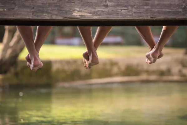 Grupo Personas Sentadas Puente Madera Sobre Río Con Enfoque Las —  Fotos de Stock