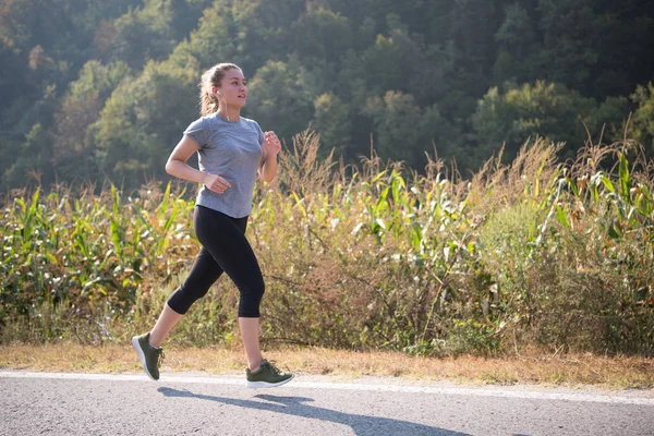 Młoda Kobieta Korzystających Zdrowego Trybu Życia Podczas Joggingu Wzdłuż Drogi — Zdjęcie stockowe