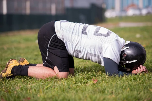 フィールドでのハードトレーニングの後に休んで疲れたアメリカのサッカー選手 — ストック写真