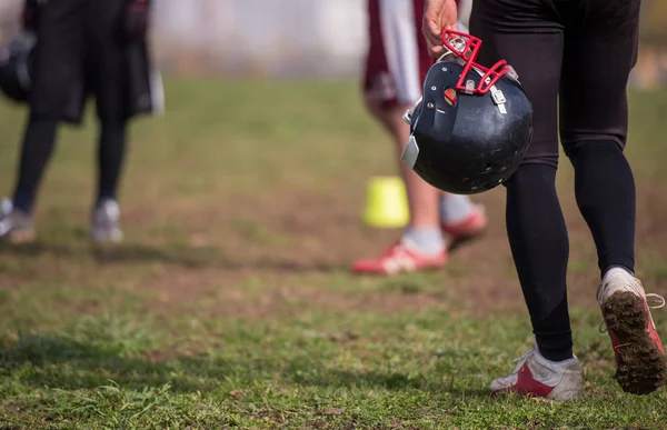 フィールドで黒いヘルメットを保持しているアメリカン フットボール選手のクローズ アップ ショット — ストック写真